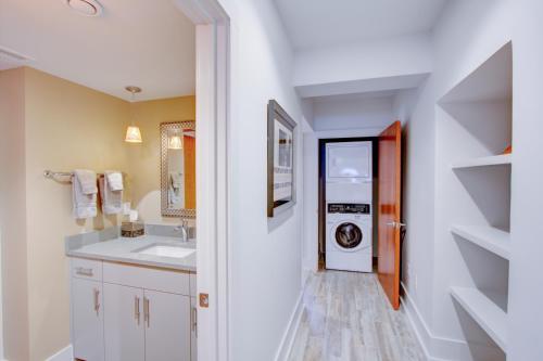 a bathroom with a sink and a washing machine at The Charleston Chestnut Mansion in Charleston