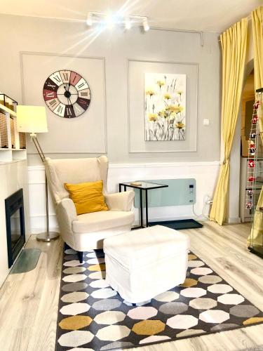 a living room with a couch and a clock on the wall at Avala Sunset Apartments in Belgrade
