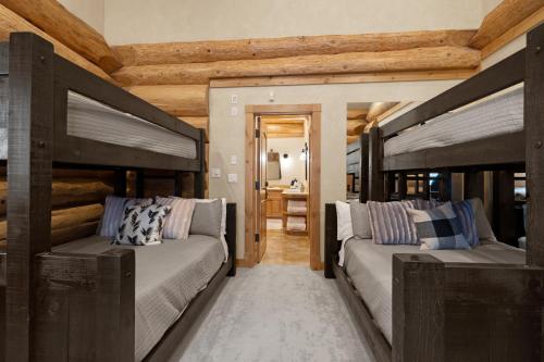 two beds in a room with wooden ceilings at The Grand Alpine Lodge in Whitefish