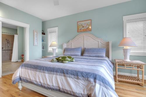 a bedroom with a large bed with blue walls at Turtle Watch Too by Oak Island Accommodations in Caswell Beach
