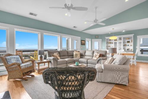 a living room with a couch and chairs at Turtle Watch Too by Oak Island Accommodations in Caswell Beach