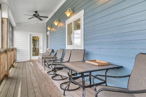 a row of chairs and a table on a porch at Turtle Watch Too by Oak Island Accommodations in Caswell Beach