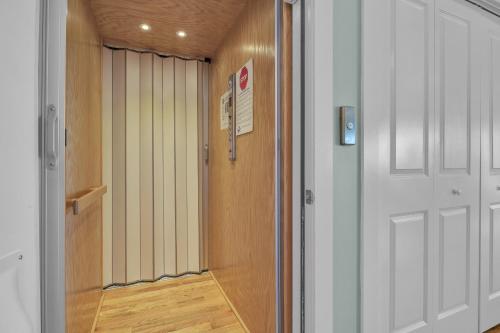 a hallway with a white door and a wooden floor at Turtle Watch Too by Oak Island Accommodations in Caswell Beach