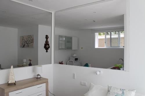 a white room with a large mirror on the wall at Quinta de Santa Bárbara Casas Turisticas in Lagoa