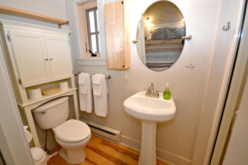ein Badezimmer mit Toilette, Waschbecken und Spiegel in der Unterkunft Walker's Cottage in Whitefish