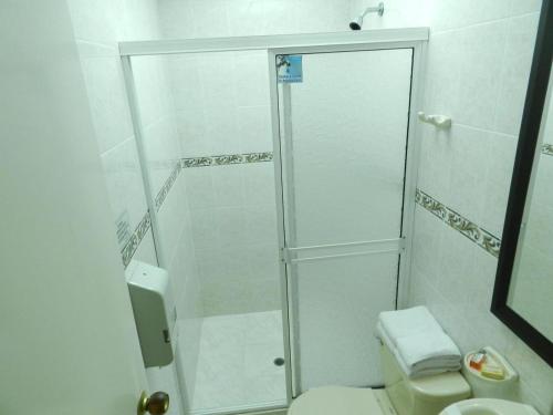 y baño con ducha, aseo y lavamanos. en Hotel Palma 70, en Medellín