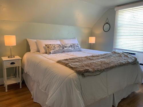 una camera da letto con un grande letto con due lampade e una finestra di Walker's Place a Outback Mobile Home Settlement