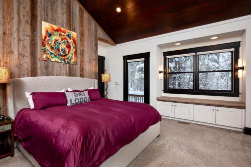 a bedroom with a purple bed and a window at Whispering Pines Chalet in Whitefish