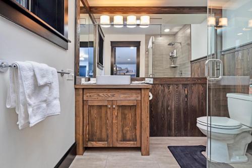 a bathroom with a sink and a toilet and a mirror at Whispering Pines Chalet in Whitefish