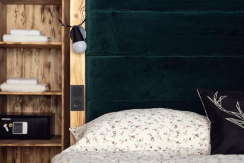 a bedroom with a green headboard and a bed at Mumlava Resort Harrachov in Harrachov