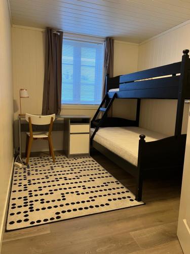 a bedroom with bunk beds with a desk and a chair at New 2 bed room apartment in Halden in Halden