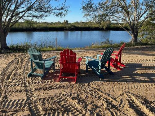 four chairs and a table in the sand near a lake at Awesome waterfront Condo #5 in Punta Gorda