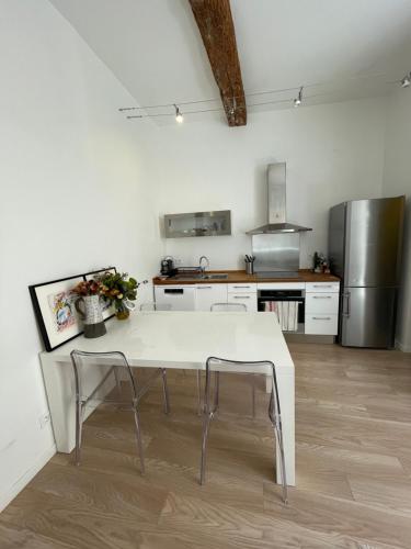 a kitchen with a white table and two chairs at Les pieds dans l’eau in Cassis