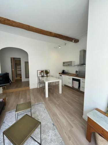 a living room with a table and a kitchen at Les pieds dans l’eau in Cassis