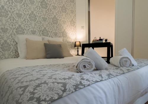 - un lit blanc avec des oreillers au-dessus dans l'établissement Diane 100 m du lac, à Annecy