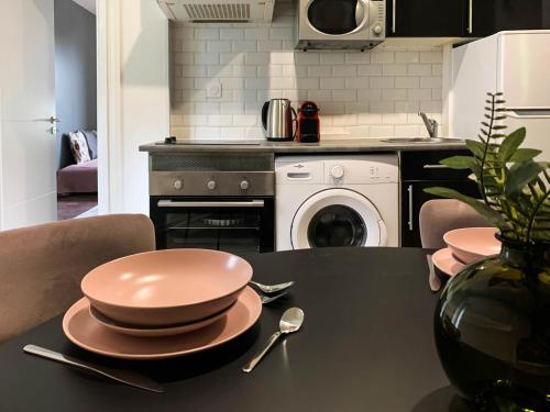 - une cuisine avec une table, des assiettes et des ustensiles dans l'établissement Diane 100 m du lac, à Annecy