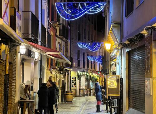 un grupo de personas caminando por una calle por la noche en LA TERRAZA DE LAUREL Aire acondicionado Insonorizado, en Logroño