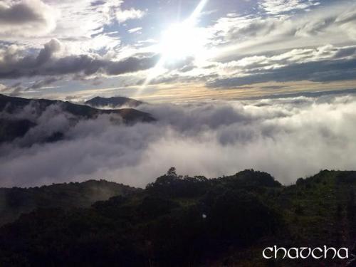 einen Blick auf einen Berg mit der Sonne über den Wolken in der Unterkunft Shirma Nua Chaucha in Cuenca
