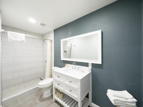 La salle de bains est pourvue d'un lavabo blanc et de toilettes. dans l'établissement Courtesy Inn & Suites, à Rosemead