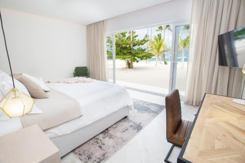 a bedroom with a bed and a view of the beach at Destination Jelly / Playa Coral Condo in Punta Cana