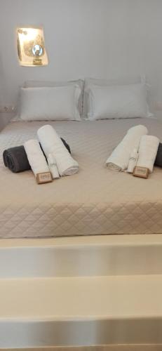 uma cama branca com duas almofadas em Idothea guest house em Amorgós