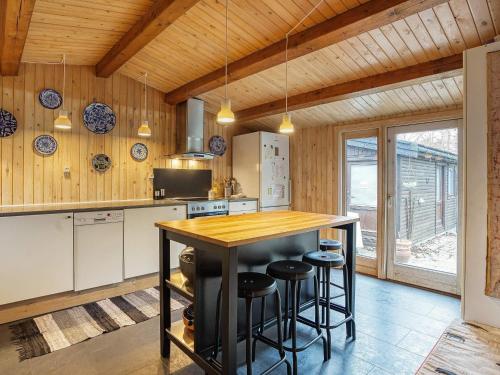a kitchen with wooden walls and a counter with stools at 8 person holiday home in Holb k in Holbæk