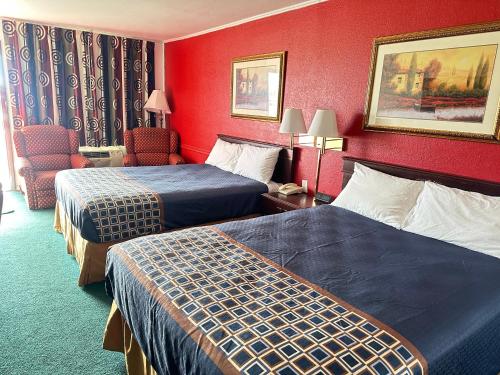 Pokój hotelowy z 2 łóżkami i krzesłem w obiekcie Gateway Inn w mieście Sullivan