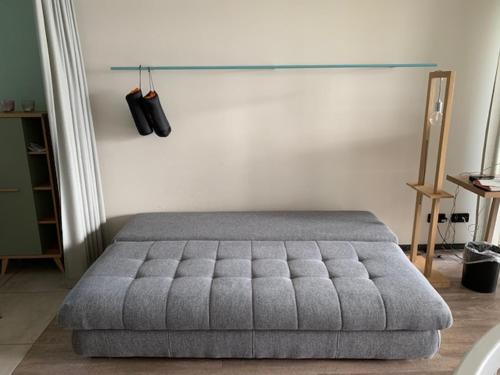 a bedroom with a gray tufted bed in a room at Ferienwohnung am See mit Terrasse in Ascheberg