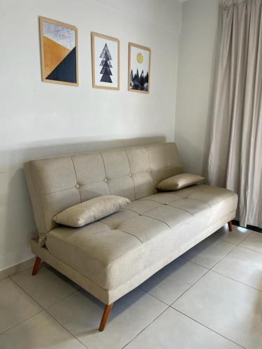 un sofá sentado en una sala de estar bajo algunas fotos en Federal 498 en La Rioja