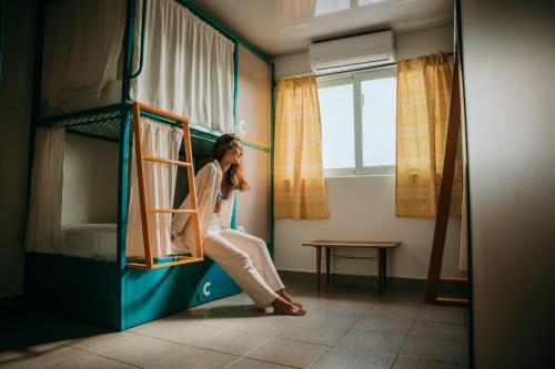 a woman is sitting in a bunk bed at Viajero San Andres Hostel in San Andrés