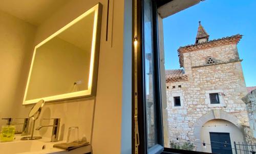 uno specchio su un muro accanto a un edificio di DOMAINE DE LEJOS - Portes d'Albi a Lamillarié