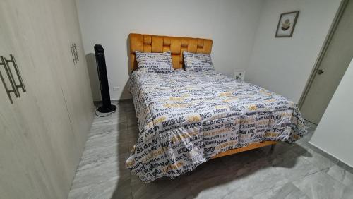 1 dormitorio con cama con edredón y almohadas en Apartamento Entero Ibague - Parqueadero - Nogal, en Ibagué