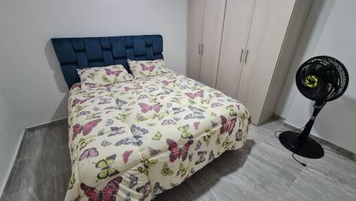 1 dormitorio con 1 cama y ventilador en el suelo en Apartamento Entero Ibague - Parqueadero - Nogal, en Ibagué