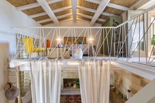 Zimmer mit einem Tisch mit Vorhängen und einer Decke in der Unterkunft Corte del Parco in Muro Leccese