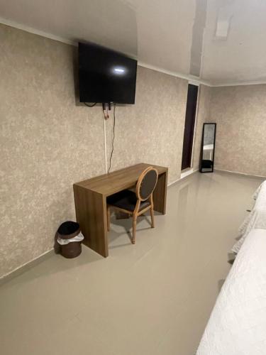 a desk with a chair and a tv on a wall at Apartahotel Marbella in San Andrés