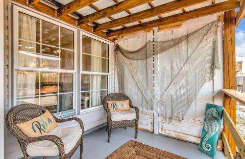 eine Veranda mit 2 Stühlen und einem Fenster in der Unterkunft Sugar Reef Cottage #4 in Fort Walton Beach