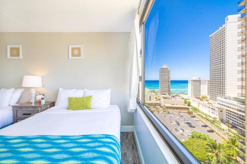a bedroom with a bed and a window with a view of the beach at Aloha Vibes, Ocean & City Views with Free Parking! in Honolulu