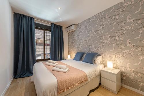 - une chambre avec un lit doté d'oreillers bleus dans l'établissement BNBHolder II Santiago Bernabeu, à Madrid