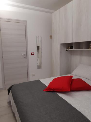 um quarto com uma almofada vermelha numa cama em Soleil Royal piano terra em Viareggio