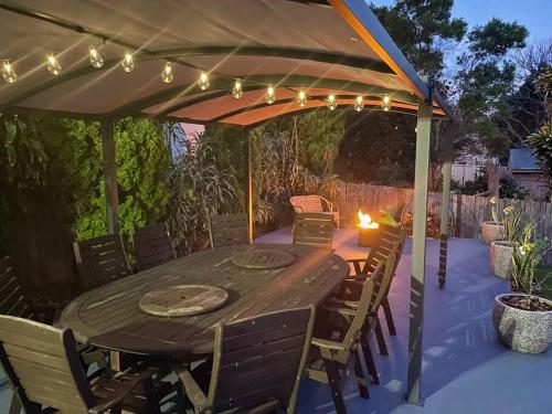 a wooden table and chairs under an umbrella at 'Anchor Management' Recently Renovated 3BR / 2BTH in Nelson Bay