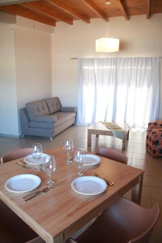 聖拉斐爾的住宿－Departamentos Los Sauces，一张木桌,上面放有盘子和酒杯