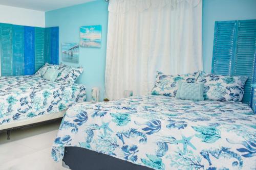 a bedroom with two beds and blue walls at Miami Boho Beach Place in Hialeah