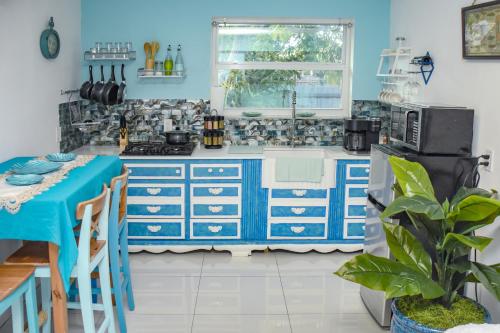 una cucina con armadi blu e piano di lavoro blu di Miami Boho Beach Place a Hialeah