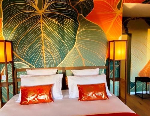 a bed with two pillows in front of a colorful wall at DOMAINE DE LEJOS - Portes d'Albi in Lamillarié