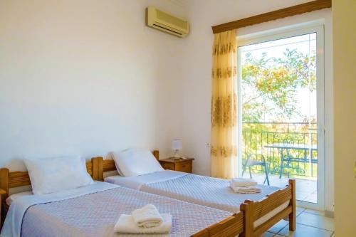 um quarto com 2 camas e uma janela em Villa Afroditi in Chania near Airport with Private Pool, Free Wi-Fi, Souda Bay Views, Garden Oasis em Kounoupidhianá