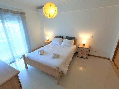 een slaapkamer met een groot bed met 2 lampen erop bij Algarve modern T1 apartment with balcony in Albufeira in Albufeira