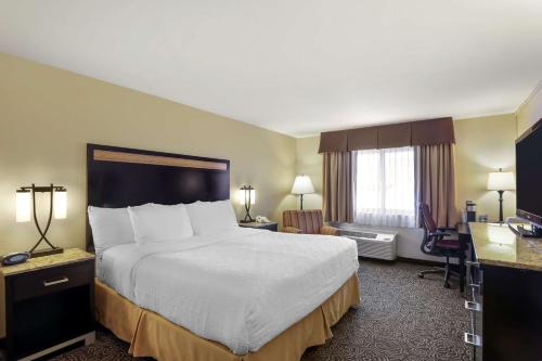 a hotel room with a large bed and a desk at Best Western Plus Castle Rock in Castle Rock