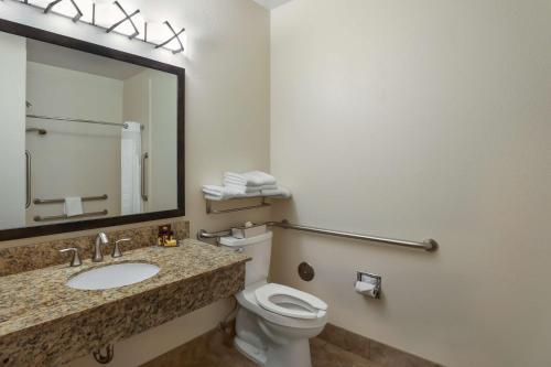 a bathroom with a sink and a toilet and a mirror at Best Western Plus Castle Rock in Castle Rock