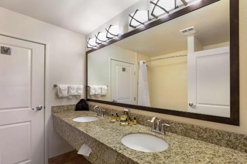 a bathroom with two sinks and a large mirror at Best Western Plus Castle Rock in Castle Rock