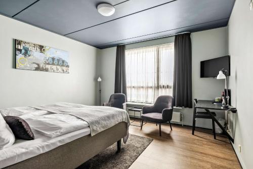 a bedroom with a bed and a desk and a chair at Best Western Royal Holstebro in Holstebro